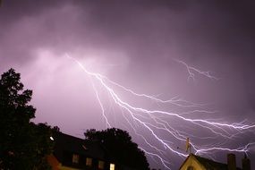 thunderstorm over houses in the night sky