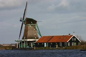 Windmill and barn near water at winter, netherlands