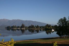 Beautiful lake with reflections of the green trees on the shoe