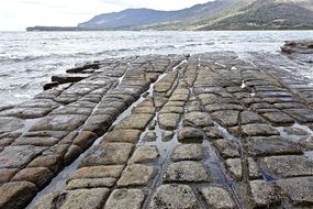 Close-up of the beautiful stone flooring on the coast among the mountains