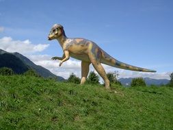 figure of a big dinosaur on the green grass in the park