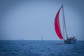 yacht with a red sail on the water