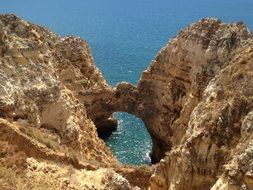 Beautiful rocky coast with green and blue water in Algarve, Portugal