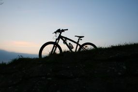 Bike on hill, silhouette at Evening sky