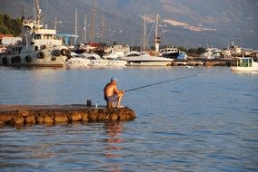 Lonely Fisherman on a sea bank