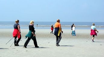 Walking humans on a North Sea beach on a sunny day