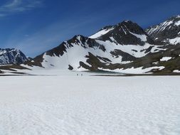 distant two persons hiking on Snow near Mountains, usa, Alaska