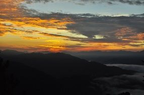 yellow sunset in the clouds over the peaks of the mountains