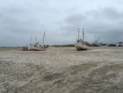 boats in the sand on a wide beach in denmark