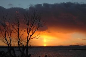 golden fiery sky over a calm lake