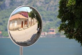 reflection of a village in a vehicle mirror