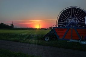 agricultural field irrigation machine at sunset