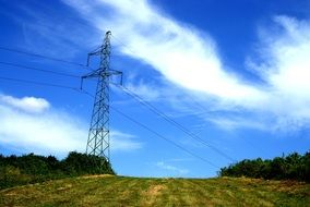 high voltage power line among green meadow