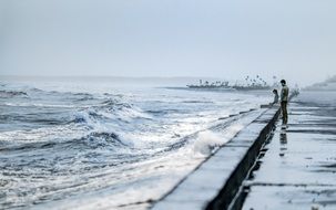 people on promenade at stormy sea, vietnam, nam dinh