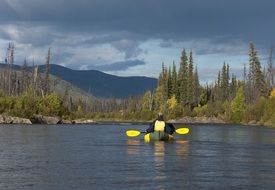 man paddling in boat on river, usa, alaska