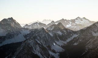 panorama of snowy peaks of high mountains in a sunny haze