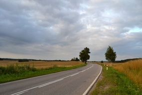 asphalt road under the sky with clouds
