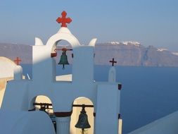 green bells on a white church in Greece