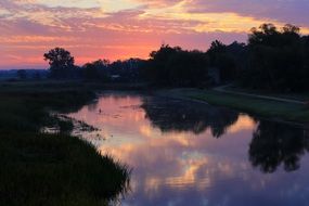 pink sunset clouds over a river in a national park in poland