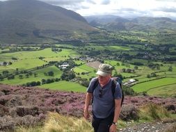 man climbing Blencathra hill at beautiful summer landscape, uk, england