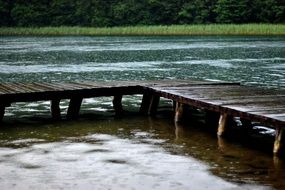 wooden pier on the lake in the rain