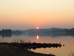 the sun on the horizon of the lake