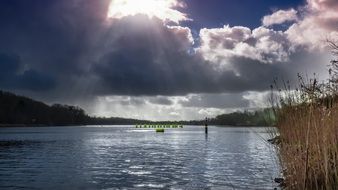 bright sunshine through dense clouds above the lake