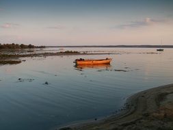 anchored Boat on calm Lake at Evening