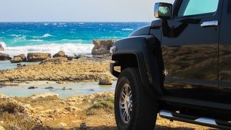 Black "Hammer" automobile near the water