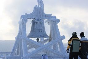 people on the background of a frozen bell in the mountains