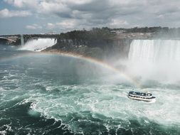 distant view of a pleasure boat under Niagara Falls