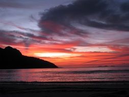 red sunset in the clouds over the coast of hawaii