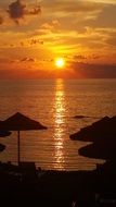 silhouette of beach umbrellas in the light of the outgoing sun