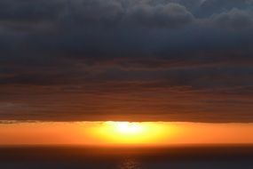sunrise behind the clouds over the horizon