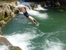 man in a jump over a waterfall