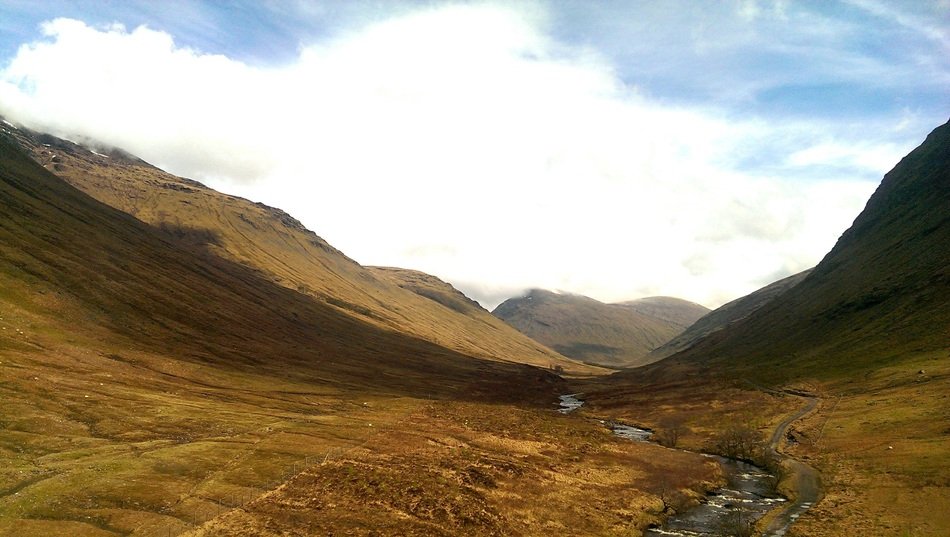 mountains in scotland with yellow grass