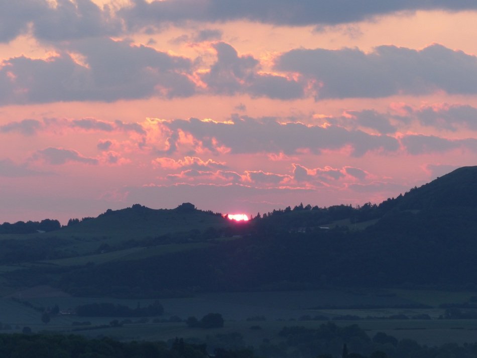 pink sunrise in the clouds over the hills