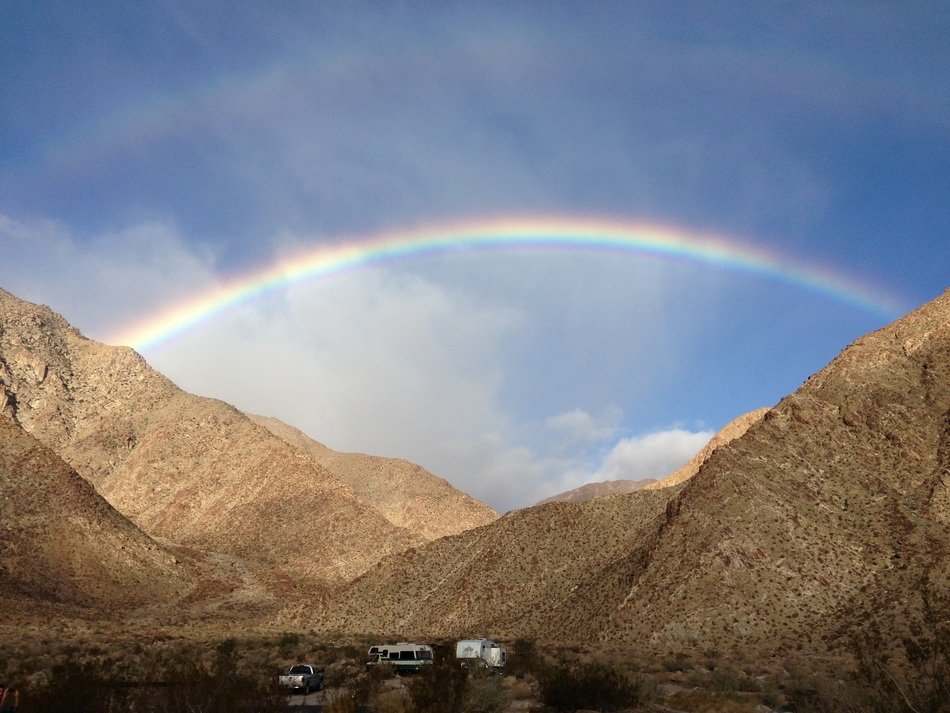 colorful rainbow over brown hills