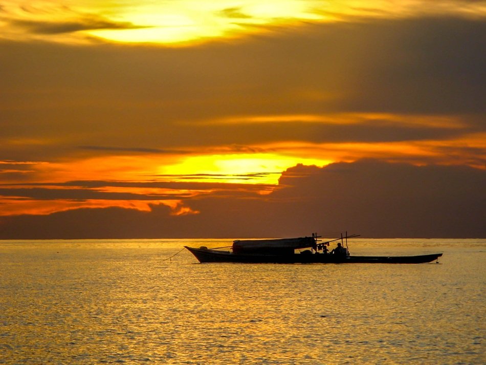 golden sunset over the boat on the water