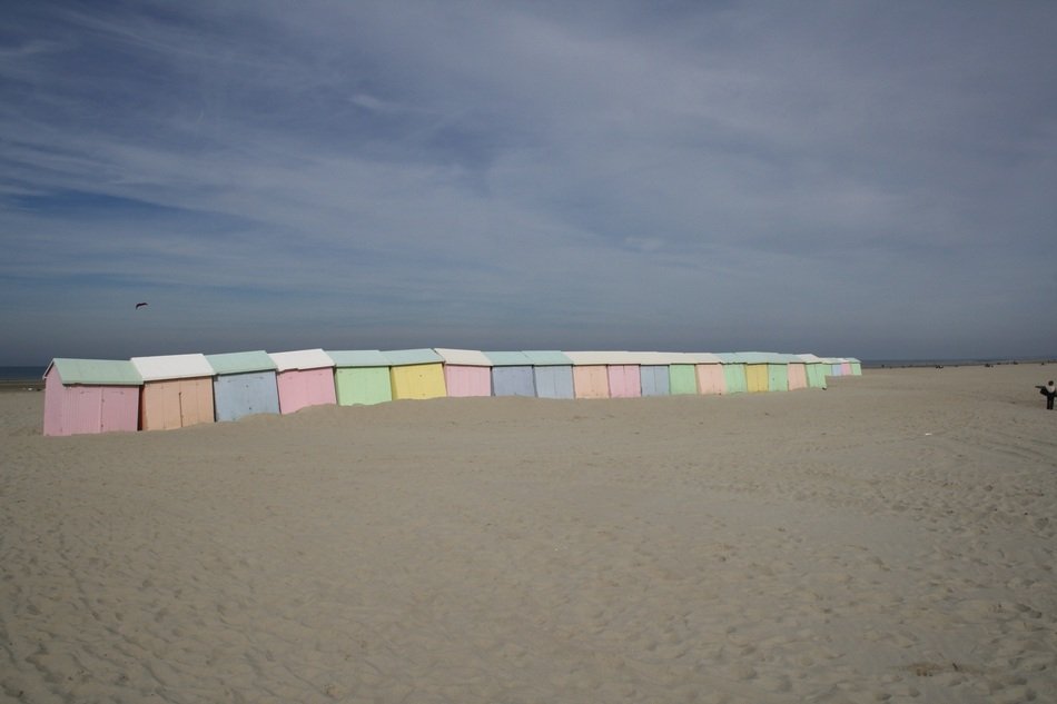 pastel colored Beach Cabinsin row on sand