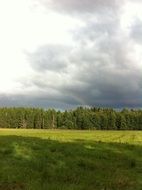 rainbow in cloudy sky in summer landscape