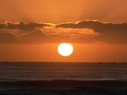 white sun on a background of orange sky at sunset