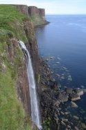 rocky shore under a waterfall