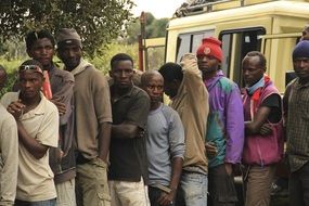 Black people stand near the bus