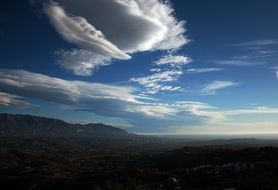 clouds in the blue sky over the hills