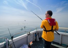 young man Fishing on boat in sea