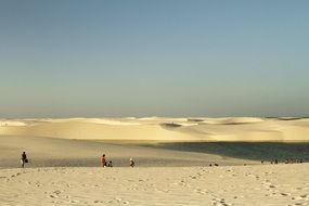 distant view of People walking by yellow Desert with hills, Brazil