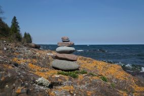 tower of pebbles on a rock by the sea