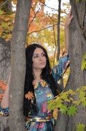 girl with long black hair among autumn trees