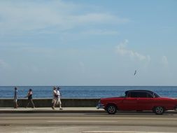 red retro car on the coast of Cuba